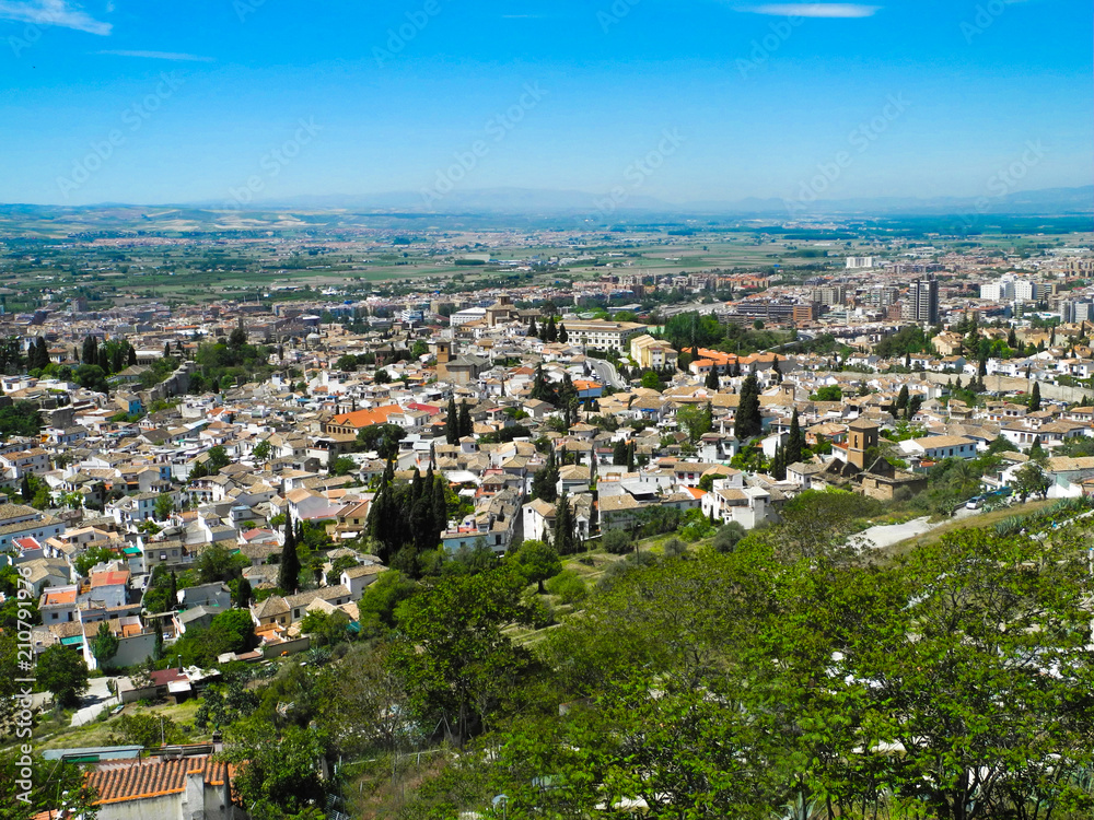 Albaicin, Old muslim quarter, white houses with orange tiling roofs, district of Granada in Spain. View from the top of Sacromonte mountain. Panorama.