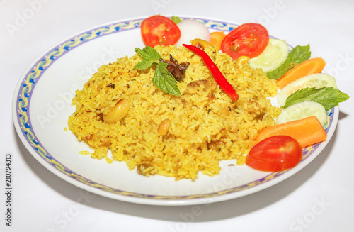 Indian meal of vegetable fried pulao rice served with salad isolated on white background.