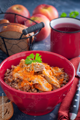Buckwheat porridge with meat in a red bowl, selective focus photo