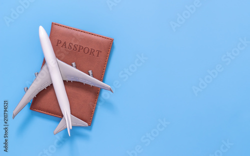 Fotografie Toy plane on top of passport on blue copy space