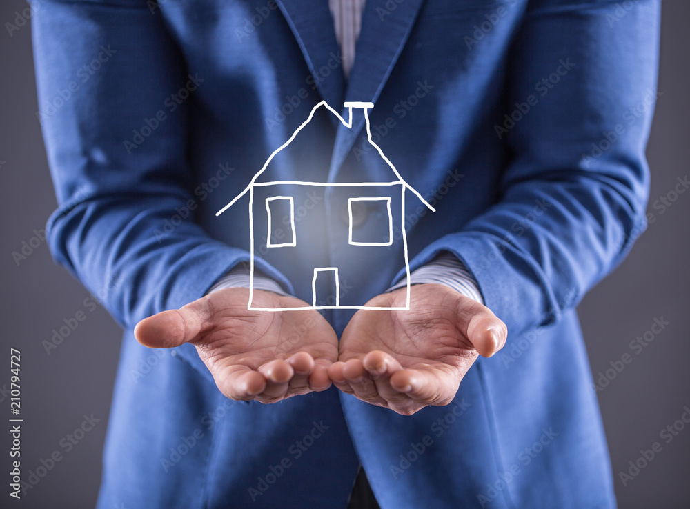 Businessman holding a deawn house on the hand Businessman holding a deawn house on the hand
