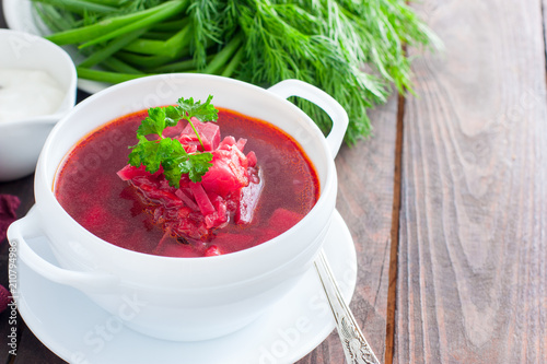 Traditional for Ukrainian and Russian cuisine vegetarian borscht in a white bowl, horizontal, copy space