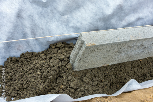 Setting of edge restraints with border stones in concrete photo