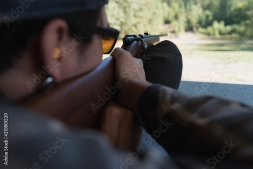 Man aiming shotgun at target in shooting range
