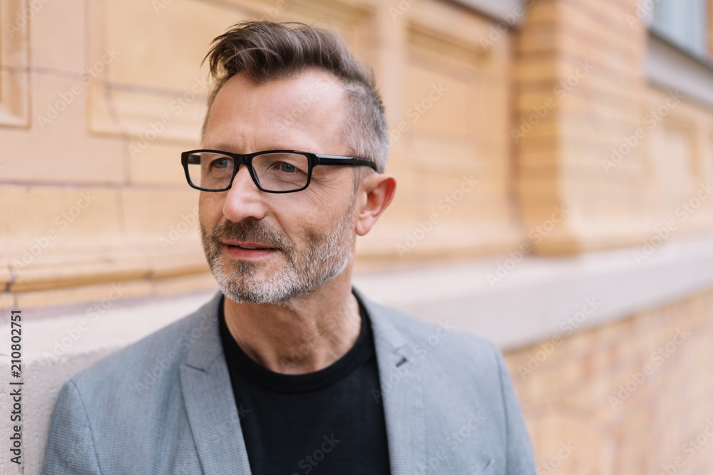smarter älterer mann mit brille unterwegs in der stadt smarter älterer mann mit brille unterwegs in der stadt