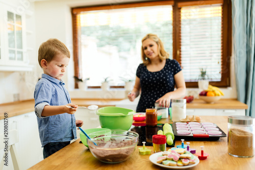 Smart cute child helping mother in kitchen