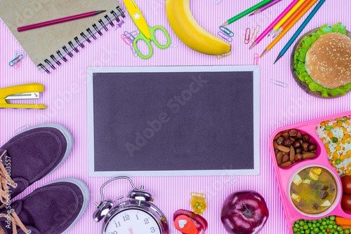 top view of blackboard and tray with kids lunch for school on violet surface