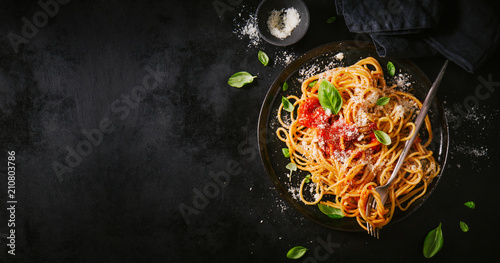 Valokuva Dark plate with italian spaghetti on dark