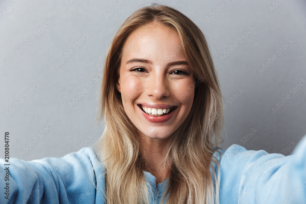 Close up of smiling young blonde girl taking a selfie Close up of smiling young blonde girl taking a selfie