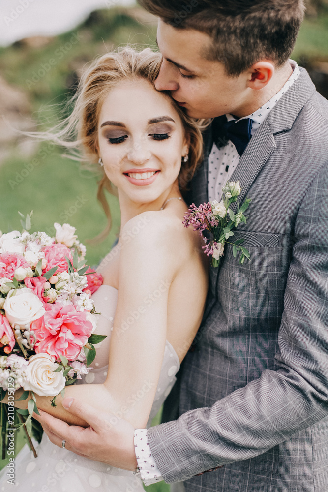 beautiful bride and groom in wedding dresses on nature background beautiful bride and groom in wedding dresses on nature background