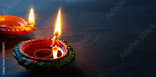 Happy Diwali - Close up of lit Diya lamps on floor
