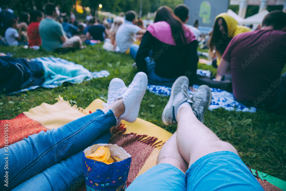 people watching movie in open air cinema in city park