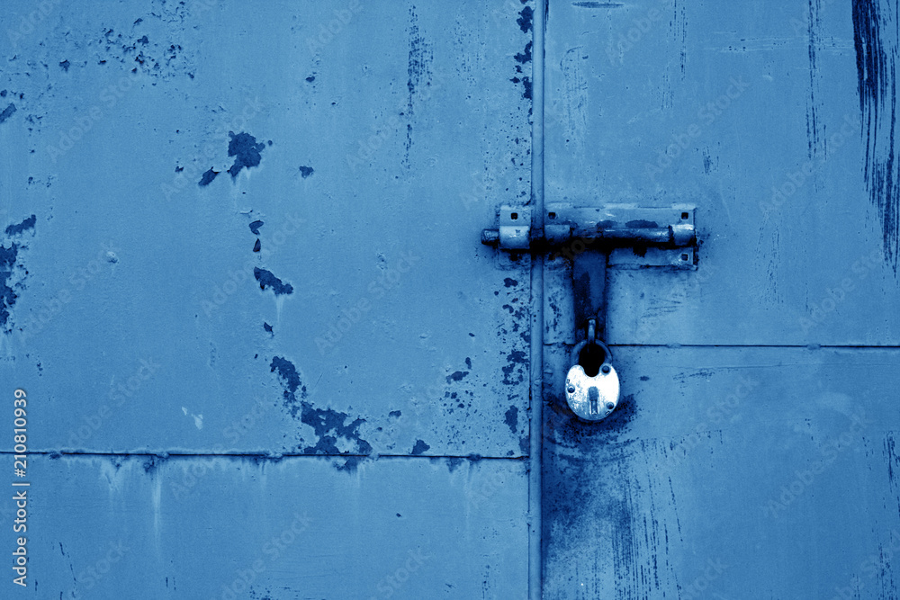 Old padlock on metal gate in navy blue color. Old padlock on metal gate in navy blue color.