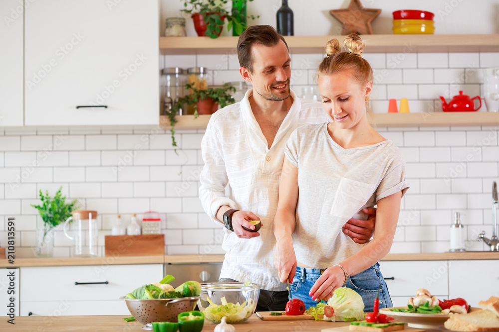 Image of young couple in love preparing breakfast in kitchen Image of young couple in love preparing breakfast in kitchen