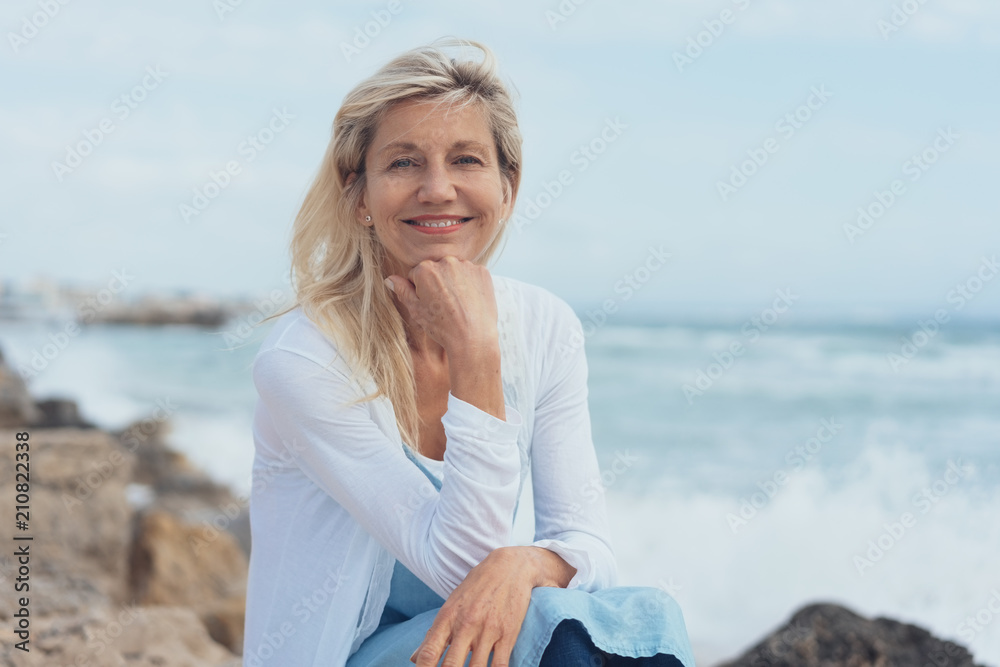 glückliche best-agerin sitzt am meer und entspannt glückliche best-agerin sitzt am meer und entspannt