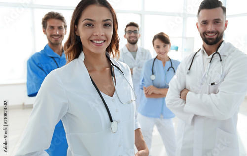 Attractive female doctor with medical stethoscope in front of medical group