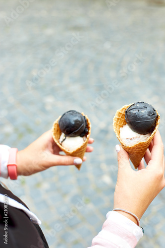 Female  in hand charcoal and vanila ice cream