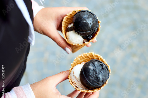 Female in hand charcoal and vanila ice cream