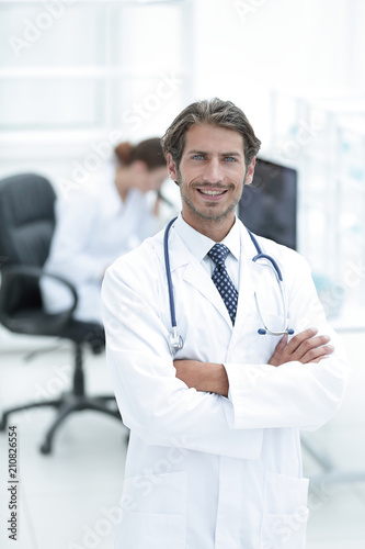 Handsome male doctor smiling with arms crossed on chest portrait