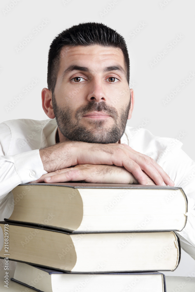 Portrait of young handsome student with pile of books, education concept, studio isolated picture Portrait of young handsome student with pile of books, education concept, studio isolated picture