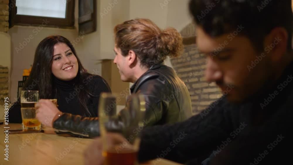 young couple chatting at the counter while a sad and lonely man drinking beer young couple chatting at the counter while a sad and lonely man drinking beer
