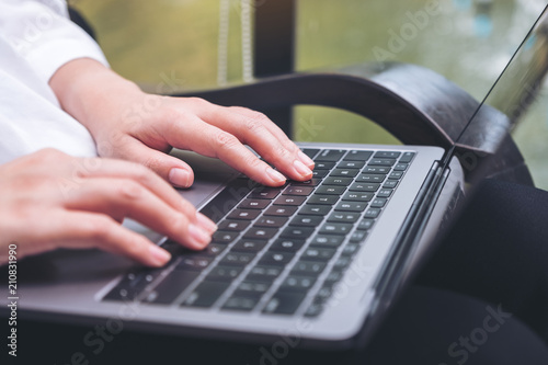 Closeup image of a business woman's hands working and typing on laptop keyboard