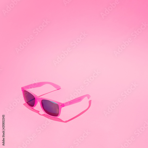 Pink sunglasses on pastel background. Minimal summer concept.