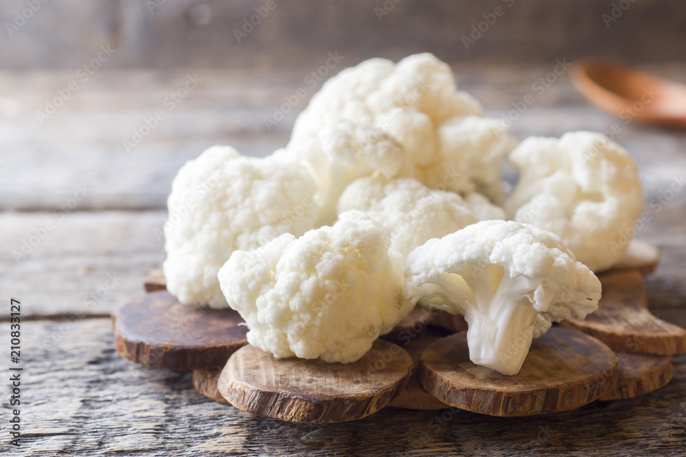 Cauliflower fresh organic, cut into small pieces on wooden background Cauliflower fresh organic, cut into small pieces on wooden background