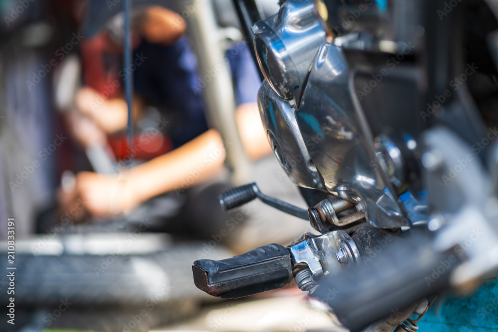 Automobile mechanic repairing motorcycle in bike repair shop Automobile mechanic repairing motorcycle in bike repair shop