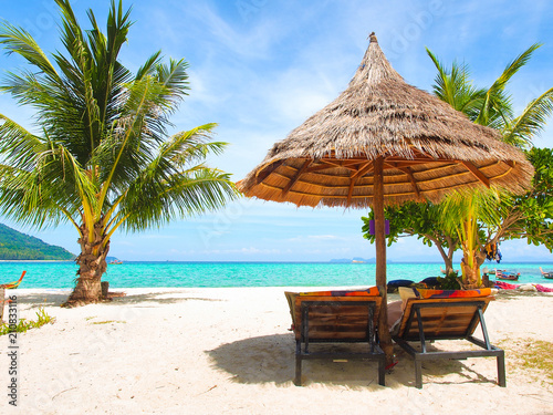 Fototapeta Naklejka Na Ścianę i Meble -  Wooden beach chairs and straw parasol on white sand beach with turquoise water sea and clear blue sky in sunny summer day at Koh Lipe island in Thailand for vacation holiday concept.