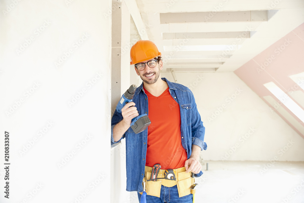Handyman using hammer drill driver on construction site Handyman using hammer drill driver on construction site