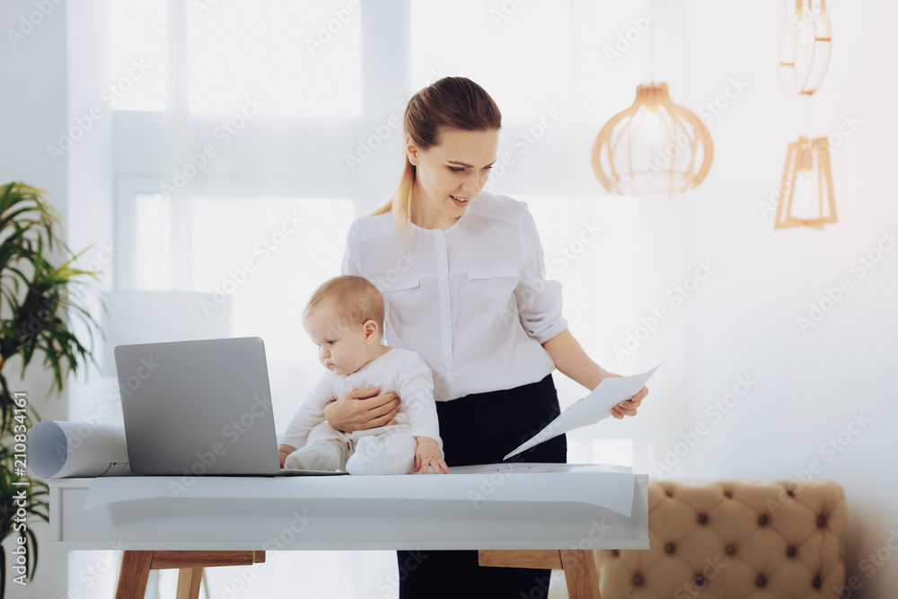 Baby girl. Funny child pressing lips while staring at screen of laptop Baby girl. Funny child pressing lips while staring at screen of laptop