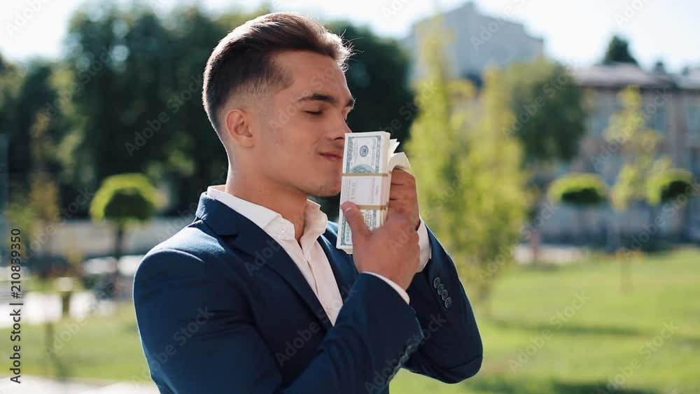 Young businessman with money. A successful man is happy about money. Money does not smell. Successful business. Shot on Red Epic Young businessman with money. A successful man is happy about money. Money does not smell. Successful business. Shot on Red Epic