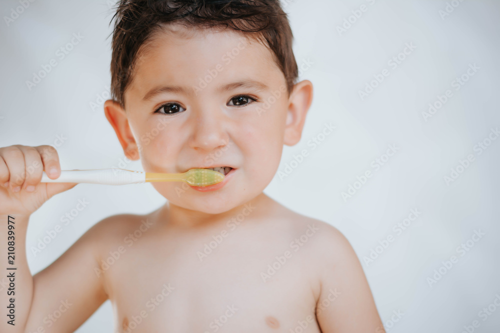 Kid learning how to stay healthy. Health care concept.Little boy brushing his teeth on white background Kid learning how to stay healthy. Health care concept.Little boy brushing his teeth on white background