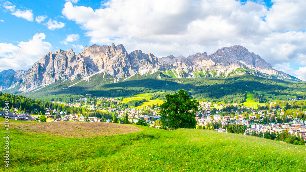 Panorama of Cortina d'Ampezzo with green meadows and alpine peaks on the background. Dolomites, Italy Panorama of Cortina d'Ampezzo with green meadows and alpine peaks on the background. Dolomites, Italy