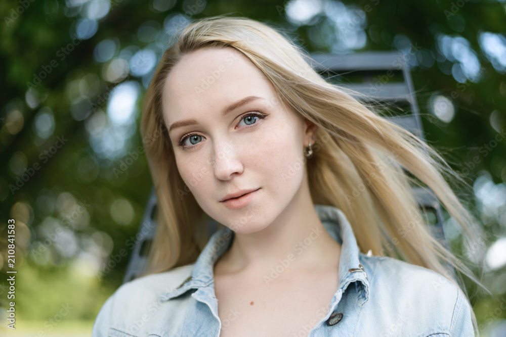 Summertime portrait of beautiful young woman with blue eyes. Selective focus.