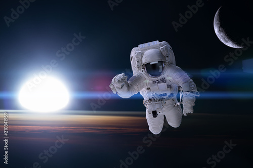 Astronaut in outer space on background of the night Earth. Elements of this image furnished by NASA.