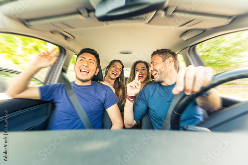 Friends inside the car singing during a road trip