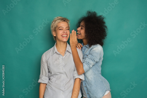 Young woman telling her friend some secrets photo