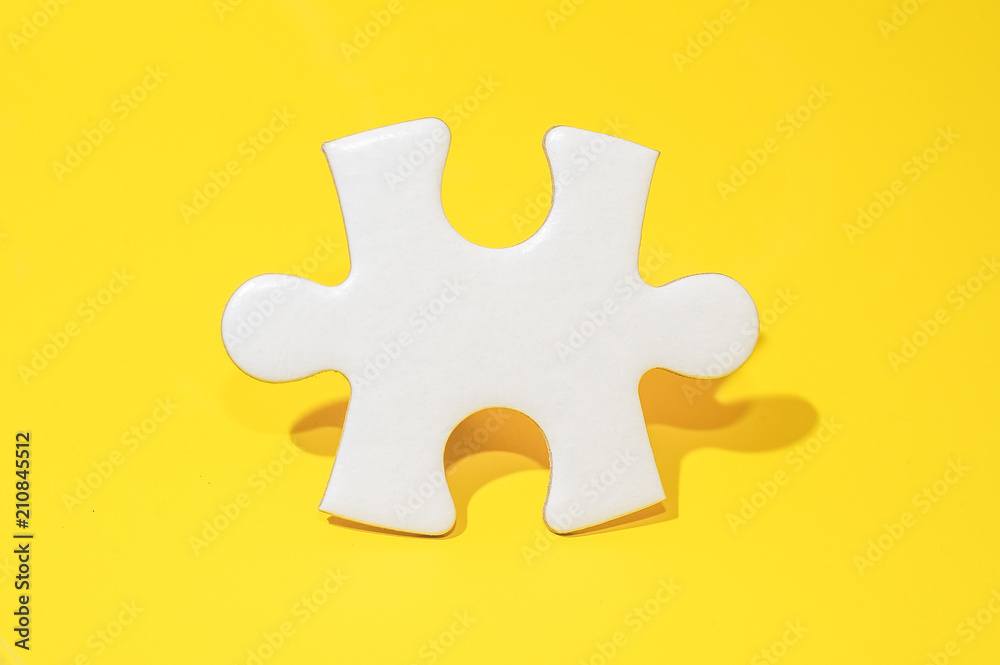 A piece of blank white puzzle on yellow background with copy space.Education and business background concept. A piece of blank white puzzle on yellow background with copy space.Education and business background concept.