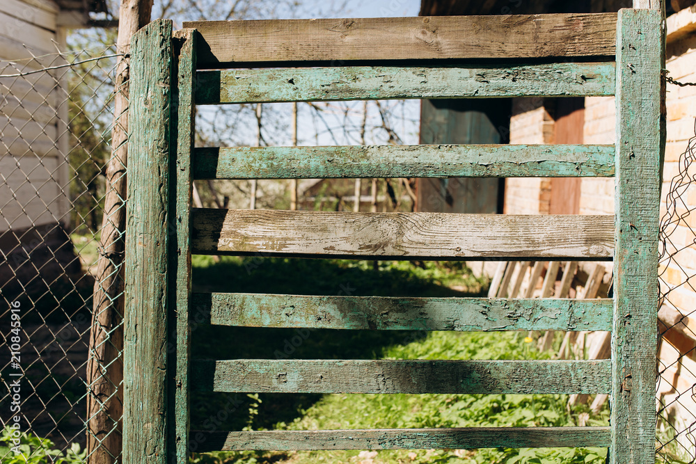Old rustic village fence background. Wooden painted planks texture with scratches. Old rustic village fence background. Wooden painted planks texture with scratches.