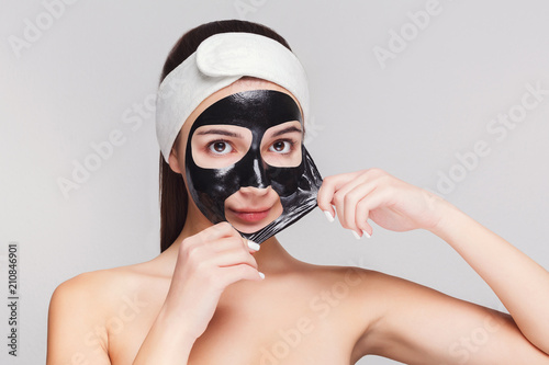 Young girl with purifying black face mask photo