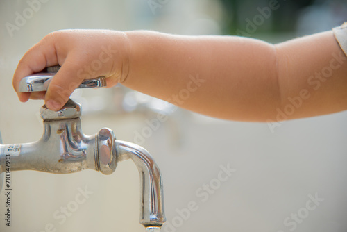 水道で手を洗う子供の手