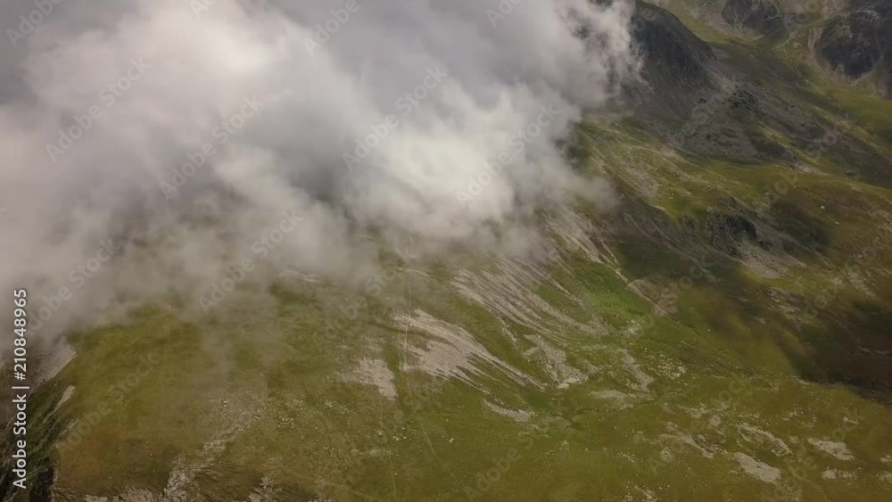 Aerial view. Panning to right over mountain landsacpe. Low altittude clouds Aerial view. Panning to right over mountain landsacpe. Low altittude clouds
