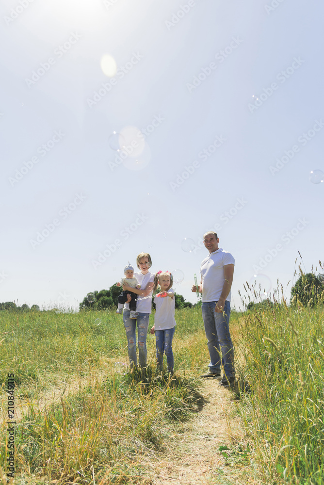 Family walks in the field. Family with soap bubbles. A family with two children. A full-fledged family.