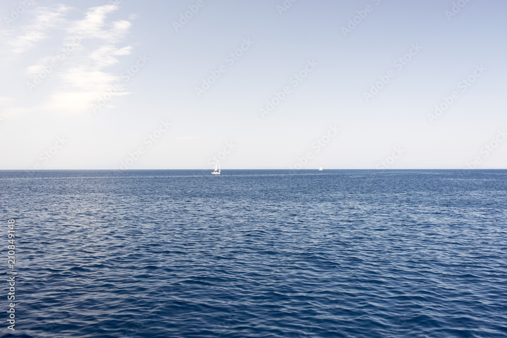 A view of a horizon at the seascape with two sailing yachts in aegean sea