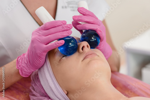 Young woman having stimulating facial massage in spa salon