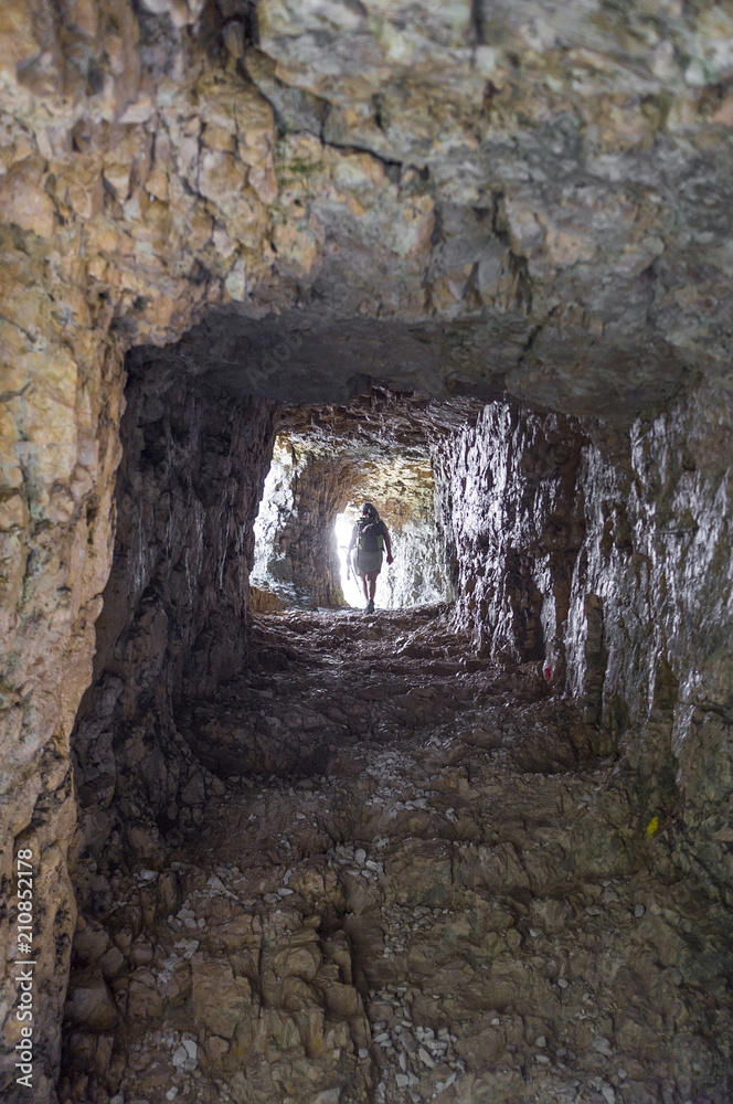 Obraz premium woman walking on the Road of 52 galleries, Veneto, Italy / Strada delle 52 gallerie (Road of 52 galleries) is a military trail built during World War I on the massif of Pasubio (Vicenza, Italy)