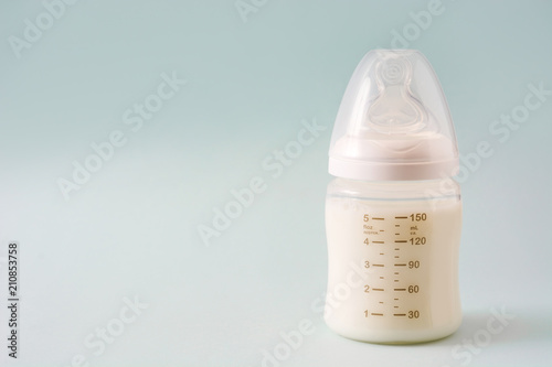 Baby bottle and milk on gray background

