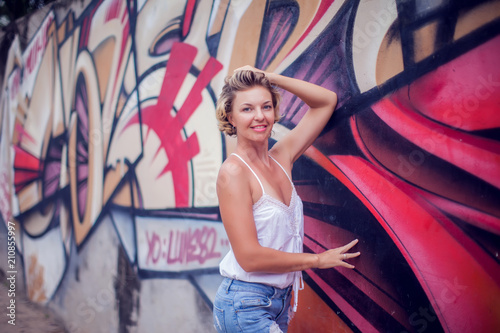 Portrait of beautiful woman posing on colorful wall background outdoors